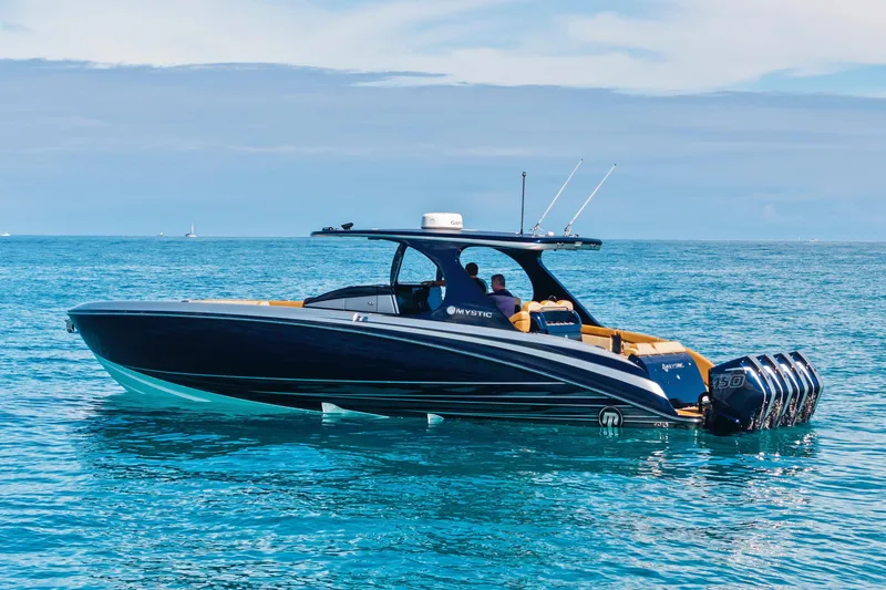 Slide: The Image of 2021 Mystic Powerboats M4200 cruising on clear blue ocean waters. - 4