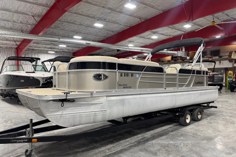 The Image of 2018 Landau Atlantis 250 pontoon boat in indoor storage on trailer. - 1