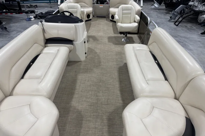 Slide: The Image of 2018 Landau Atlantis 250 pontoon boat interior with beige seating and steering console. - 14