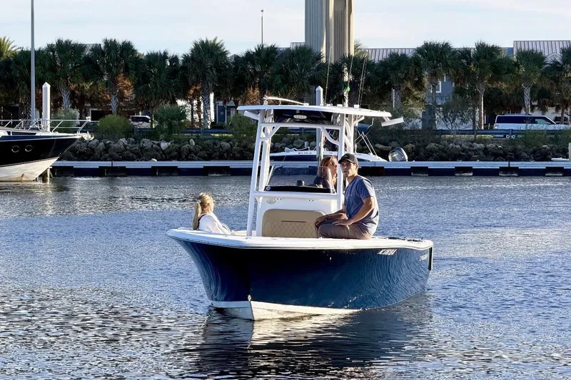 Slide: The Image of 2021 Sportsman Heritage 211 Center Console boat on calm water near a marina. - 4