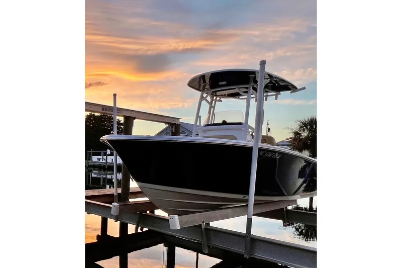 Slide: The Image of 2021 Sportsman Heritage 211 Center Console boat at sunset on a dock. - 5