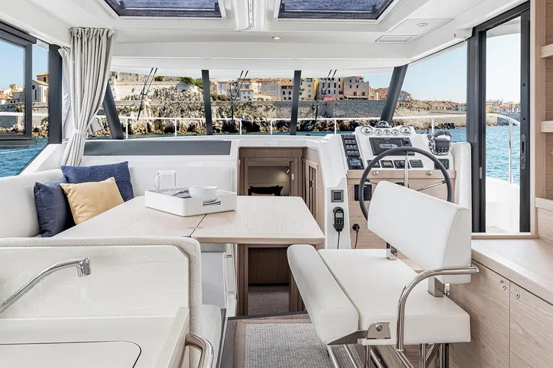 Slide: The Image of 2025 Beneteau Swift Trawler 41 Fly helm with ocean view, featuring modern navigation equipment. - 10