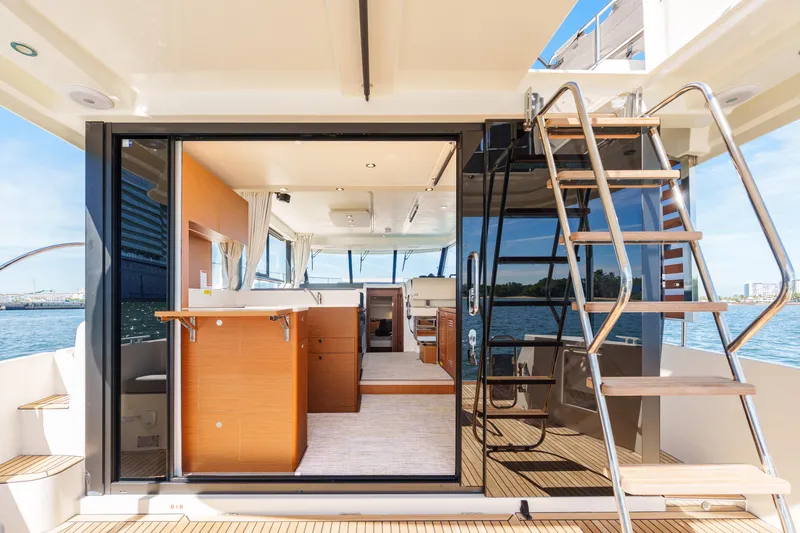 Slide: The Image of 2025 Beneteau Swift Trawler 41 Fly outdoor kitchen with grill, sink, and ocean view. - 15