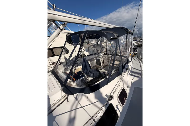 Slide: The Image of 2004 Hunter Passage 420 sailboat with cockpit enclosure, docked at marina under clear sky. - 24