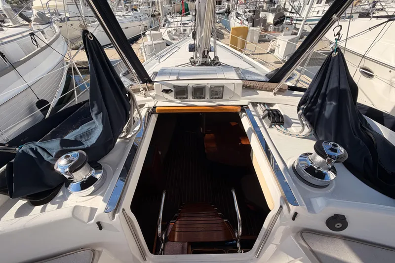 Slide: The Image of 2004 Hunter Passage 420 sailboat cockpit with winches and open hatch, docked in marina. - 40