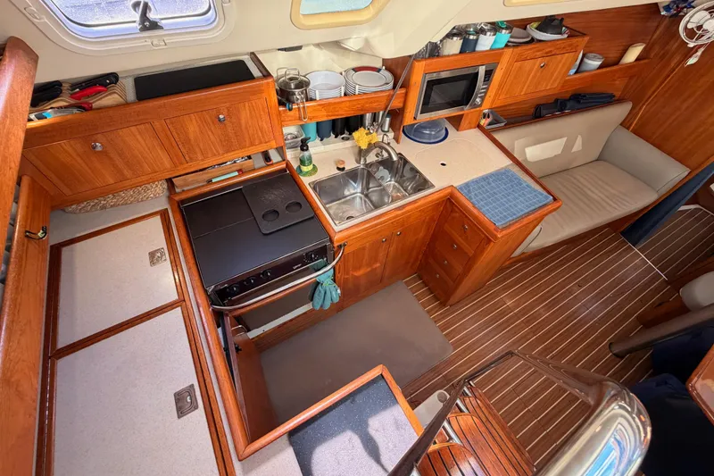Slide: The Image of 2004 Hunter Passage 420 yacht interior with wooden cabinetry, kitchen, and seating area. - 45