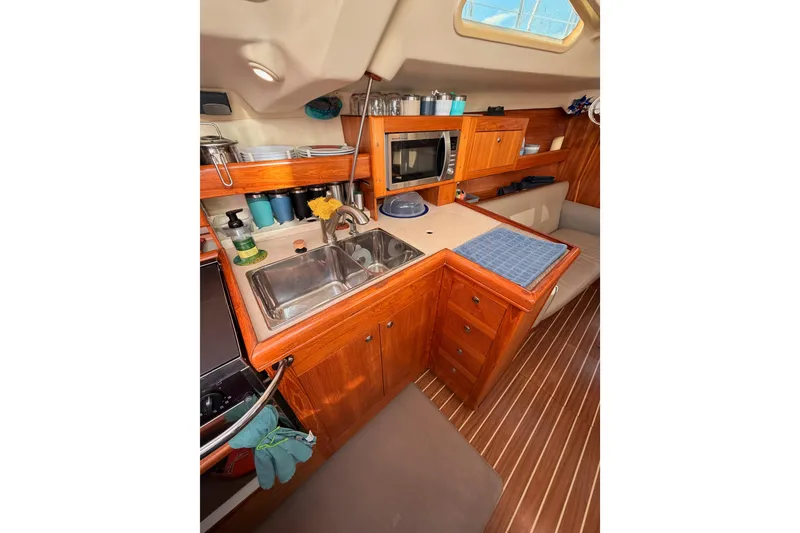 Slide: The Image of 2004 Hunter Passage 420 yacht interior kitchen with wooden cabinetry and modern amenities. - 51