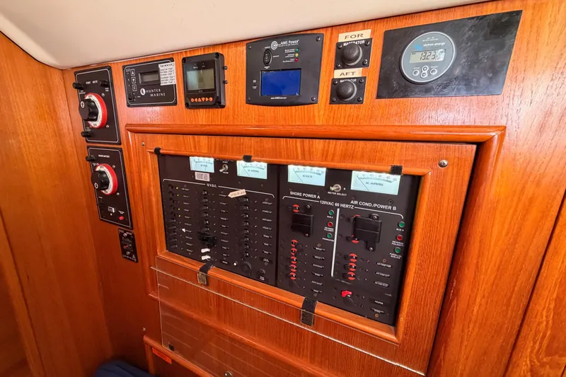 Slide: The Image of Control panel of a 2004 Hunter Passage 420 sailboat with various gauges and switches. - 58