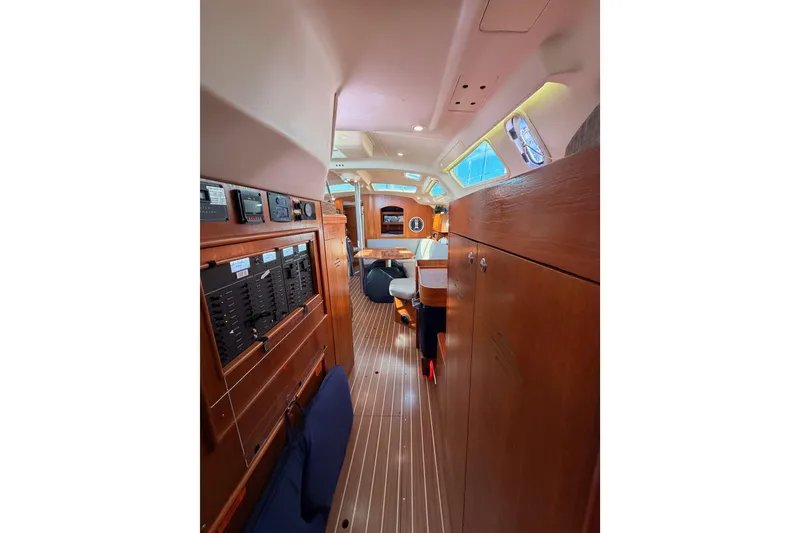 Slide: The Image of Interior of 2004 Hunter Passage 420 sailboat, featuring wood paneling and navigation equipment. - 74