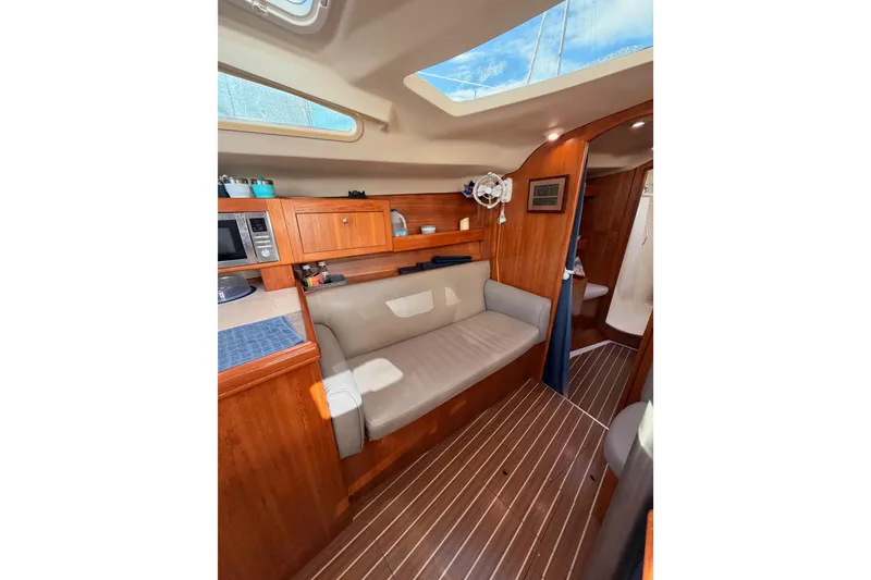 Slide: The Image of Interior of 2004 Hunter Passage 420 sailboat with wood finish and seating area. - 76
