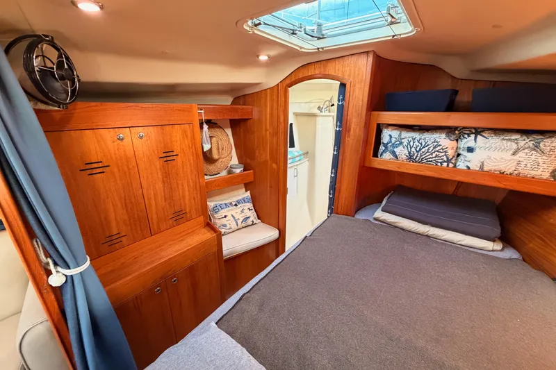 Slide: The Image of Cozy cabin interior of 2004 Hunter Passage 420 sailboat with wooden furnishings and bedding. - 80