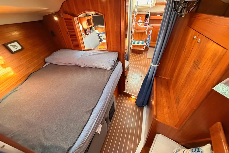 Slide: The Image of Cozy cabin interior of 2004 Hunter Passage 420 sailboat with wooden finishes and comfortable bedding. - 85