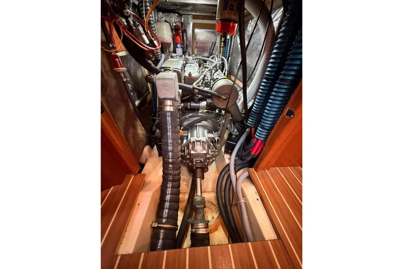 Slide: The Image of Engine compartment of a 2004 Hunter Passage 420 sailboat, showcasing mechanical components and wiring. - 91
