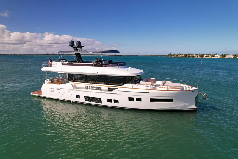 Slide: The Image of 2023 Sirena 68 yacht cruising on clear blue waters under a sunny sky. - 1