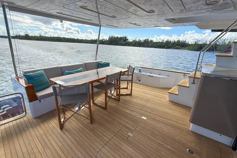 Slide: The Image of Outdoor seating area on 2023 Sirena 68 yacht with wooden deck and scenic water view. - 10