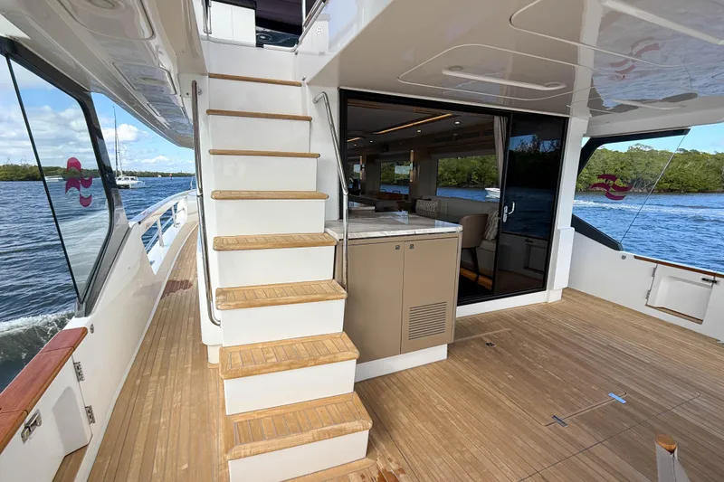 Slide: The Image of Luxurious 2023 Sirena 68 yacht interior with wooden deck and modern staircase. - 11