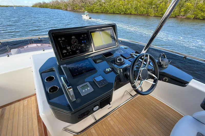 Slide: The Image of Helm of 2023 Sirena 68 yacht with advanced navigation controls and scenic waterway view. - 19