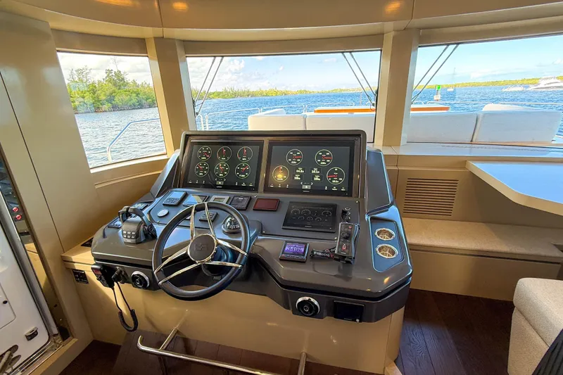 Slide: The Image of Helm of 2023 Sirena 68 yacht with modern navigation controls and scenic water view. - 36