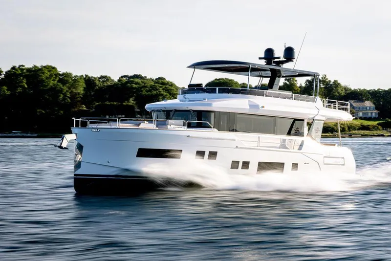 Slide: The Image of 2023 Sirena 68 yacht cruising on a serene waterway. - 4