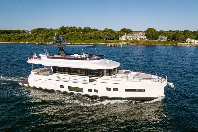 Slide: The Image of 2023 Sirena 68 yacht cruising on a scenic coastal waterway. - 5