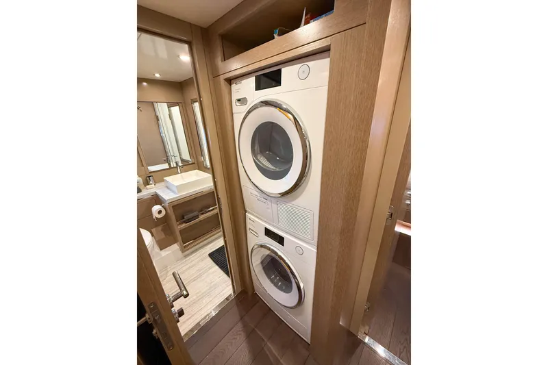 Slide: The Image of Laundry area with stacked washer and dryer in 2023 Sirena 68 yacht bathroom. - 54