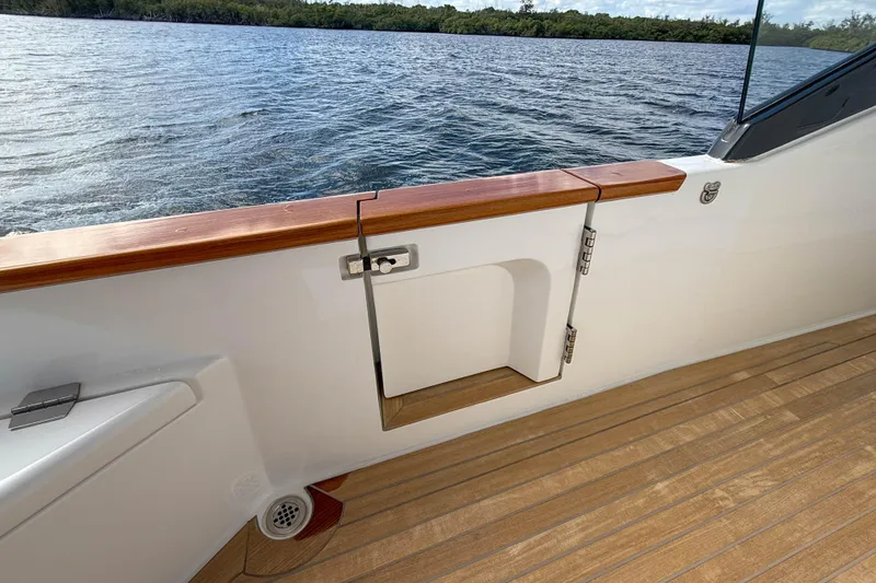 Slide: The Image of 2023 Sirena 68 yacht deck with wooden railing and water view. - 58