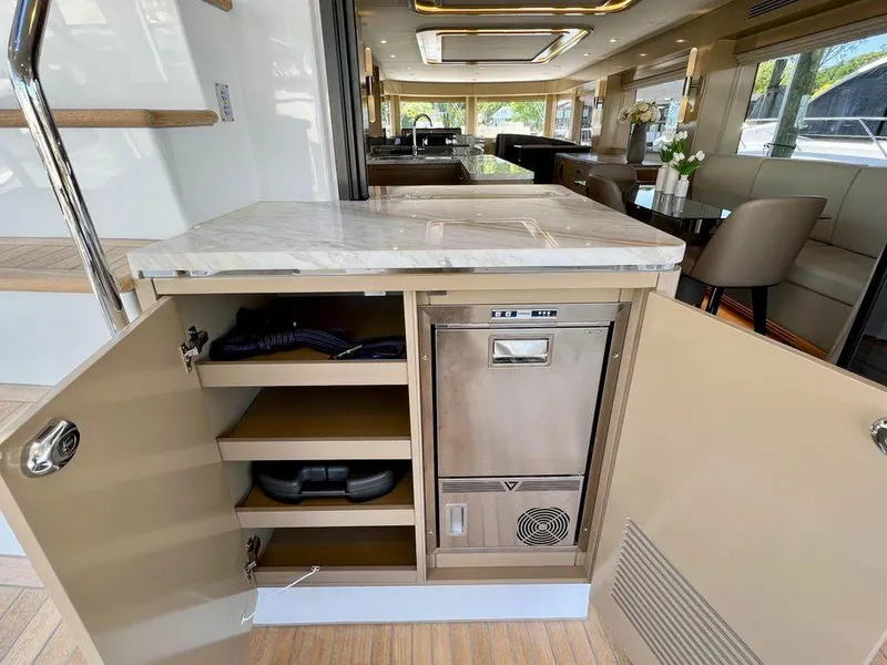 Slide: The Image of Open cabinet in the 2023 Sirena 68 yacht interior, showcasing storage and appliances. - 64