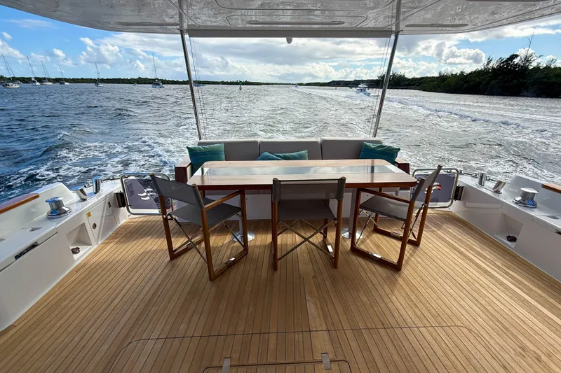 Slide: The Image of Luxurious 2023 Sirena 68 yacht deck with dining area, overlooking serene ocean waters. - 9