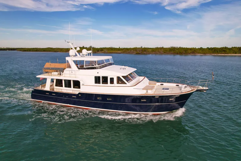 Slide: The Image of 2003 Grand Banks 64 Aleutian RP yacht cruising on calm waters under a clear sky. - 3