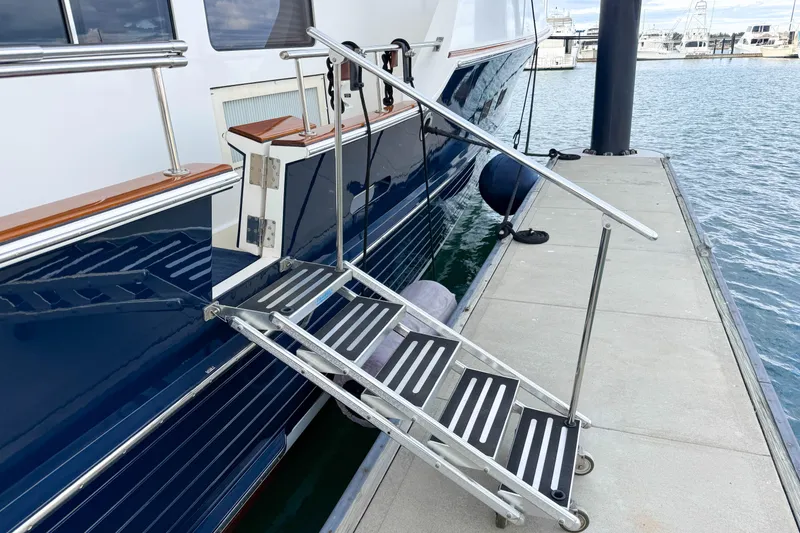 Slide: The Image of 2003 Grand Banks 64 Aleutian RP yacht deck with seating, American flag, and ocean view. - 6