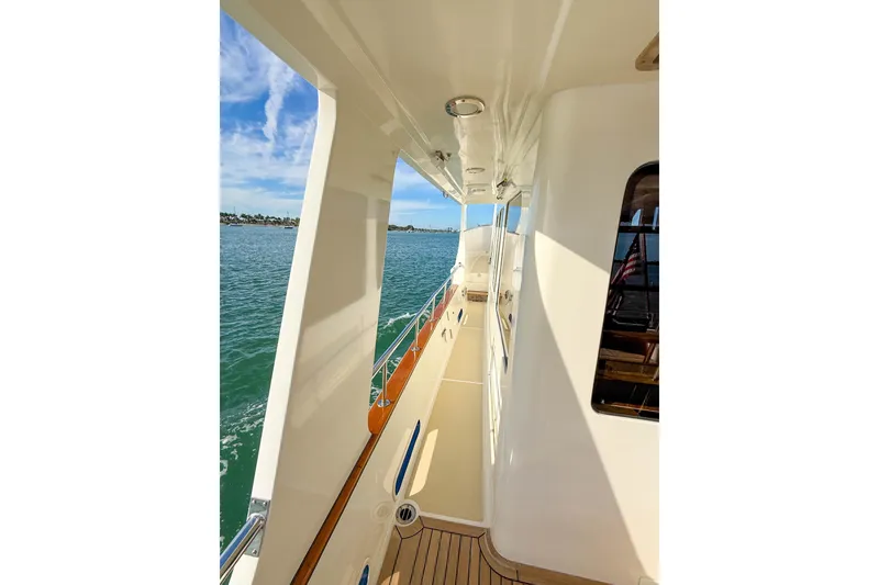 Slide: The Image of Luxurious 2003 Grand Banks 64 Aleutian RP yacht deck with sun loungers on calm water. - 68