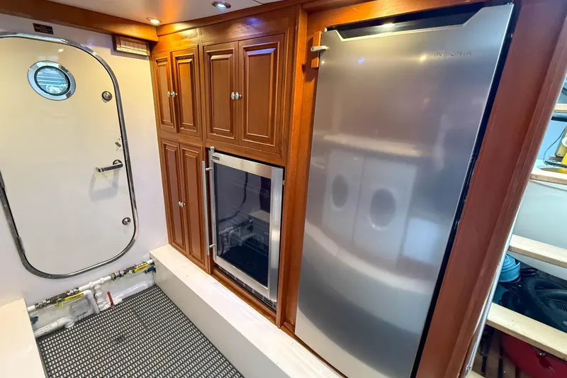 Slide: The Image of Laundry area in 2003 Grand Banks 64 Aleutian RP yacht with washer, dryer, and wooden cabinetry. - 75