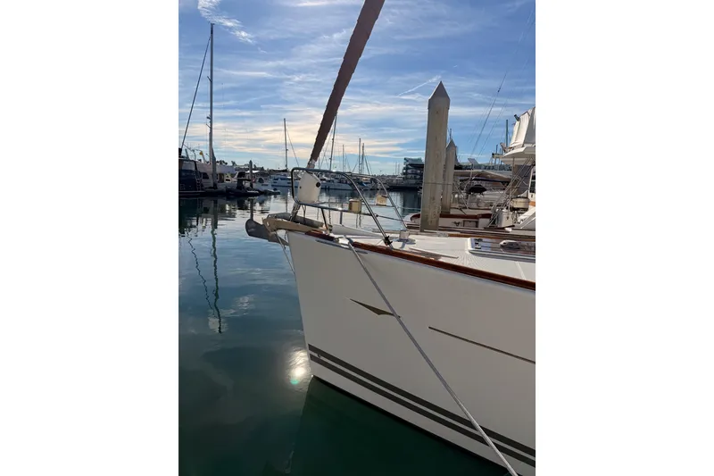 Slide: The Image of 2011 Jeanneau 53 yacht docked in a serene marina under a clear blue sky. - 10