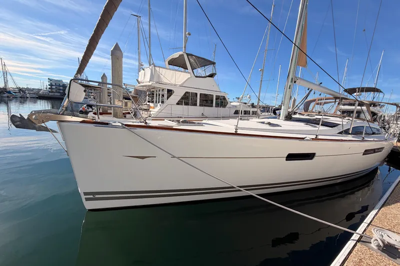 Slide: The Image of 2011 Jeanneau 53 sailboat docked in a marina under clear blue skies. - 11