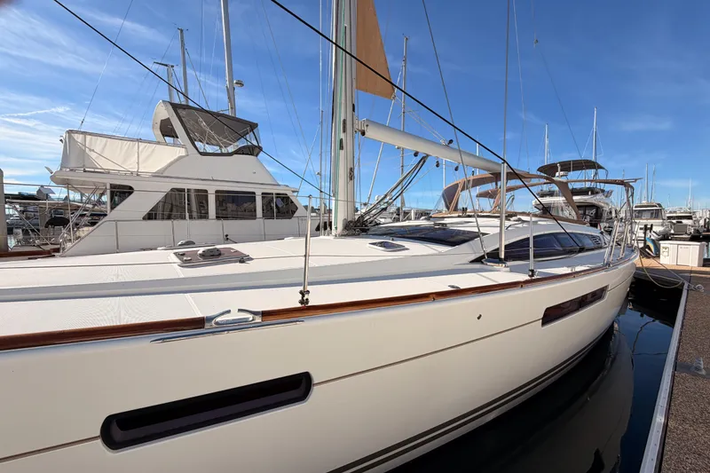 Slide: The Image of 2011 Jeanneau 53 sailboat docked in marina under clear blue sky. - 13