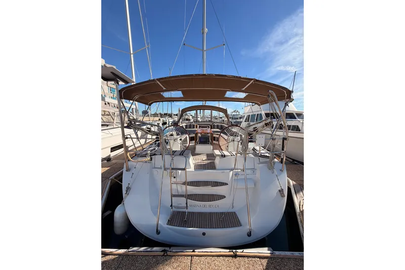 Slide: The Image of 2011 Jeanneau 53 sailboat docked, featuring dual steering wheels and a spacious cockpit. - 17