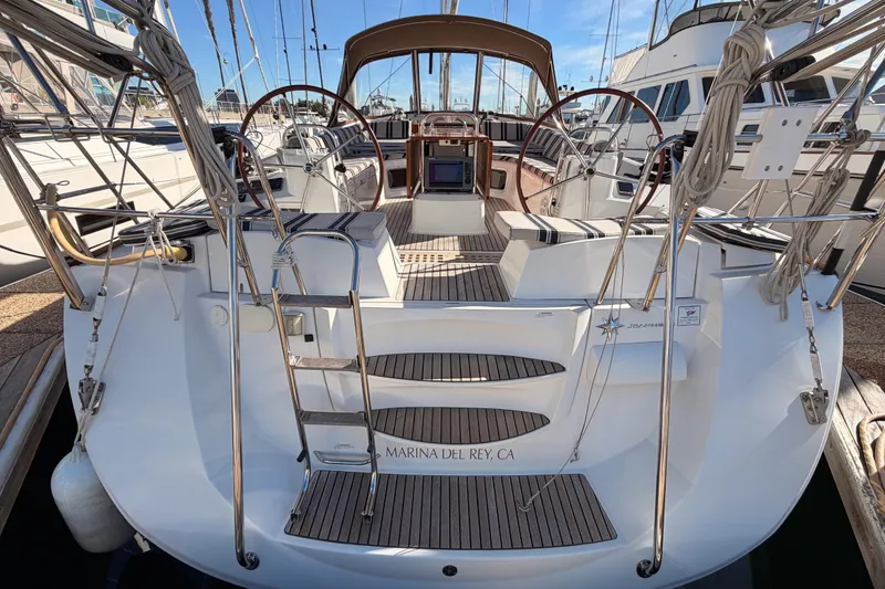 Slide: The Image of 2011 Jeanneau 53 sailboat docked at Marina del Rey, featuring dual steering wheels. - 18