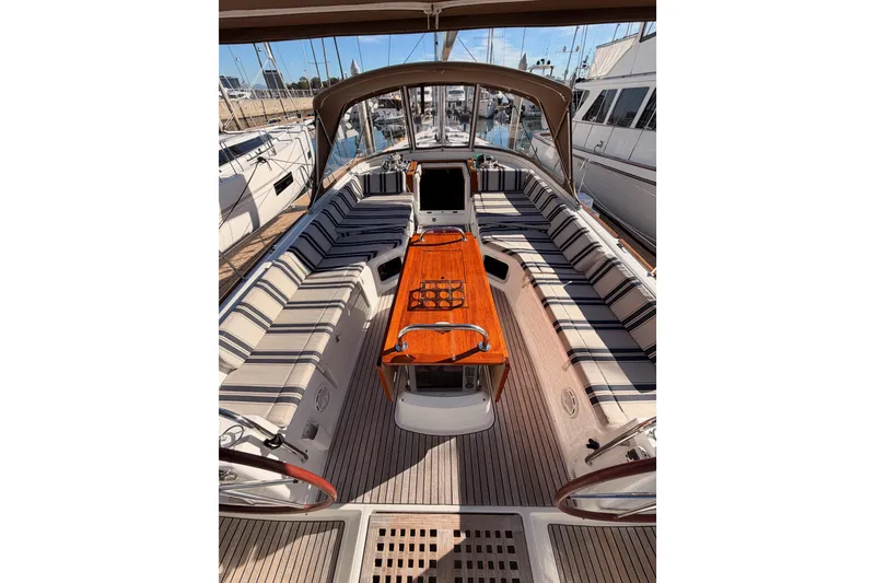 Slide: The Image of Luxurious 2011 Jeanneau 53 yacht cockpit with striped seating and wooden table. - 27