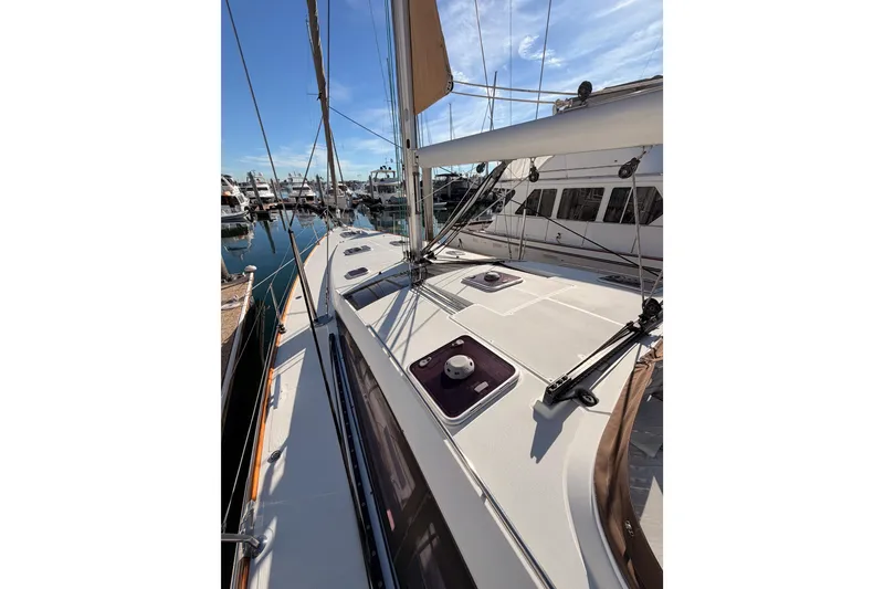Slide: The Image of 2011 Jeanneau 53 sailboat deck view in marina, showcasing sleek design and rigging. - 29