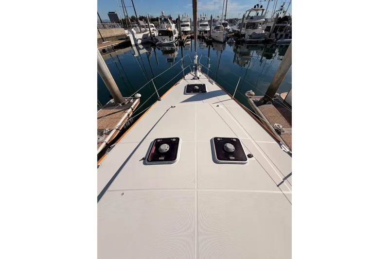 Slide: The Image of 2011 Jeanneau 53 yacht deck view in marina, showcasing sleek design and moored boats. - 30