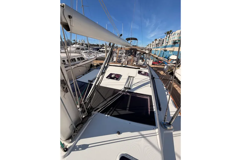 Slide: The Image of 2011 Jeanneau 53 sailboat deck view in marina under clear blue sky. - 36
