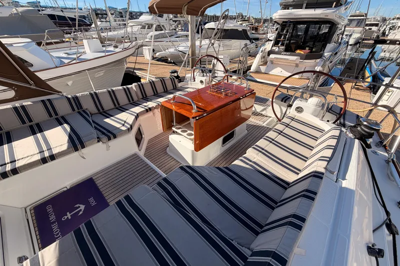 Slide: The Image of 2011 Jeanneau 53 yacht interior with striped seating and wooden table at marina. - 37