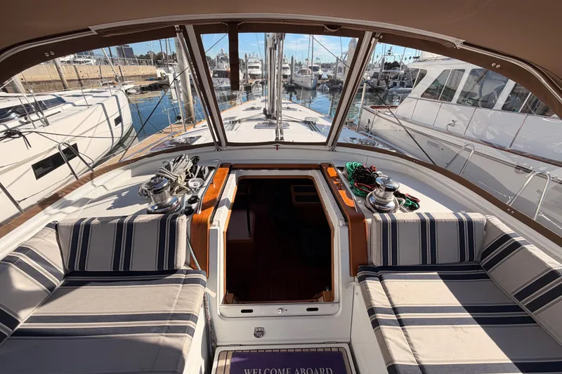 Slide: The Image of Cockpit view of 2011 Jeanneau 53 yacht with striped seating and marina backdrop. - 38