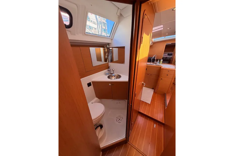 Slide: The Image of Interior of 2011 Jeanneau 53 yacht featuring a compact bathroom with wooden cabinetry. - 53