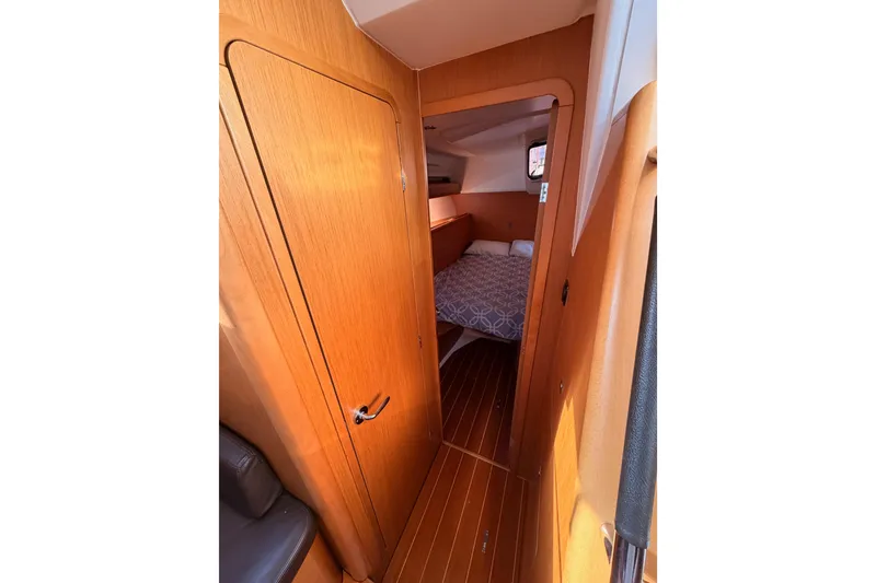 Slide: The Image of Interior view of 2011 Jeanneau 53 sailboat cabin with wooden finish and cozy bed. - 55