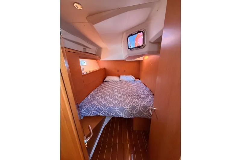 Slide: The Image of Cozy cabin interior of 2011 Jeanneau 53 sailboat with bed and wooden finish. - 57