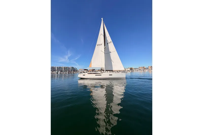 Slide: The Image of 2011 Jeanneau 53 sailboat on calm water under clear blue sky. - 6