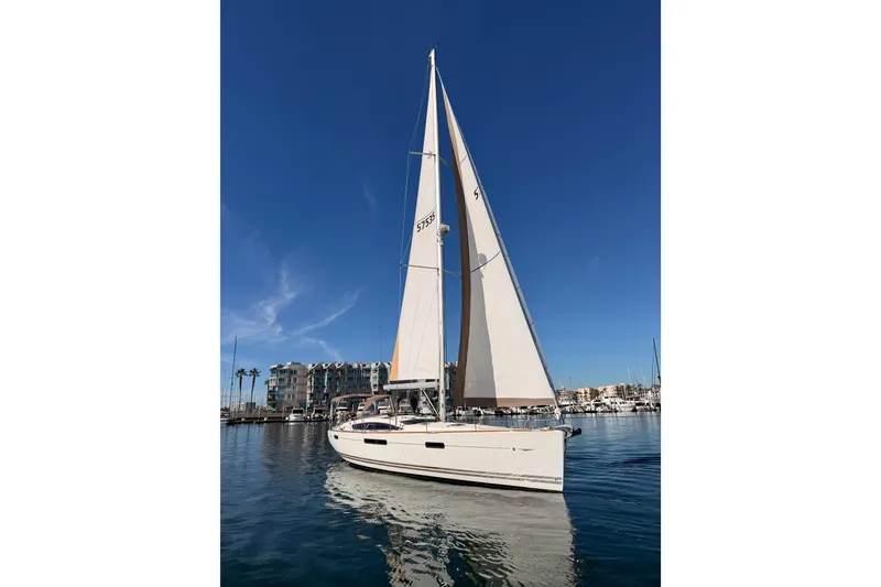 Slide: The Image of 2011 Jeanneau 53 sailboat on calm water under clear blue sky. - 7