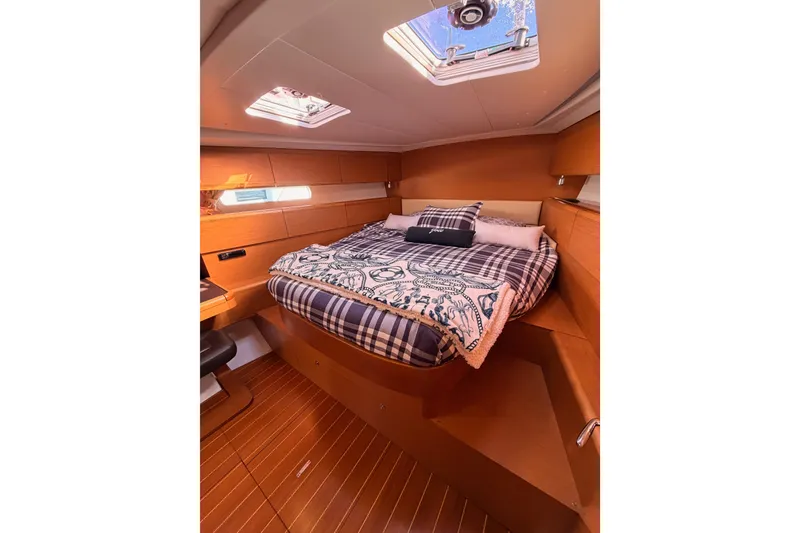 Slide: The Image of Luxurious cabin interior of 2011 Jeanneau 53 yacht with cozy bedding and wooden finish. - 77