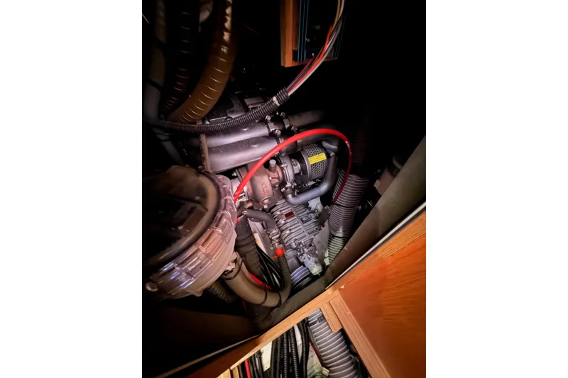 Slide: The Image of Engine compartment of a 2011 Jeanneau 53 sailboat, showcasing mechanical components and wiring. - 86